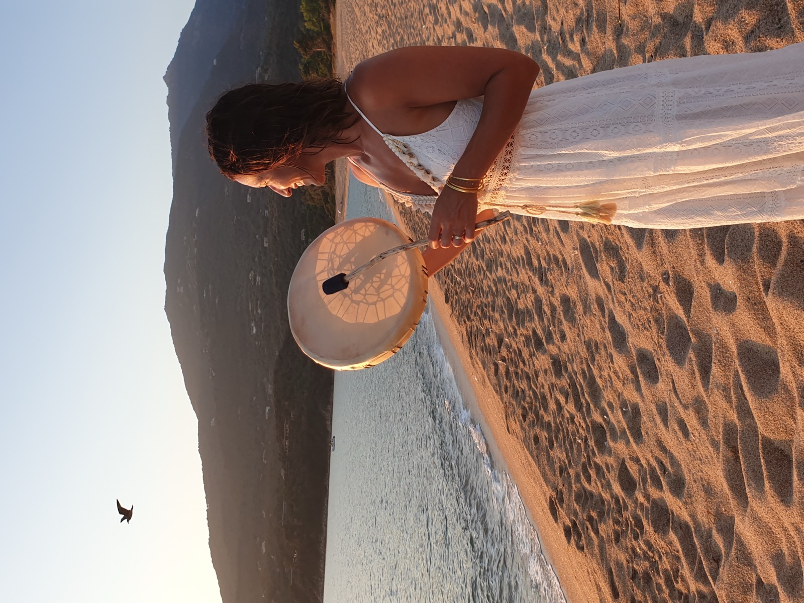 Céline avec son tambour sur la plage au coucher de soleil